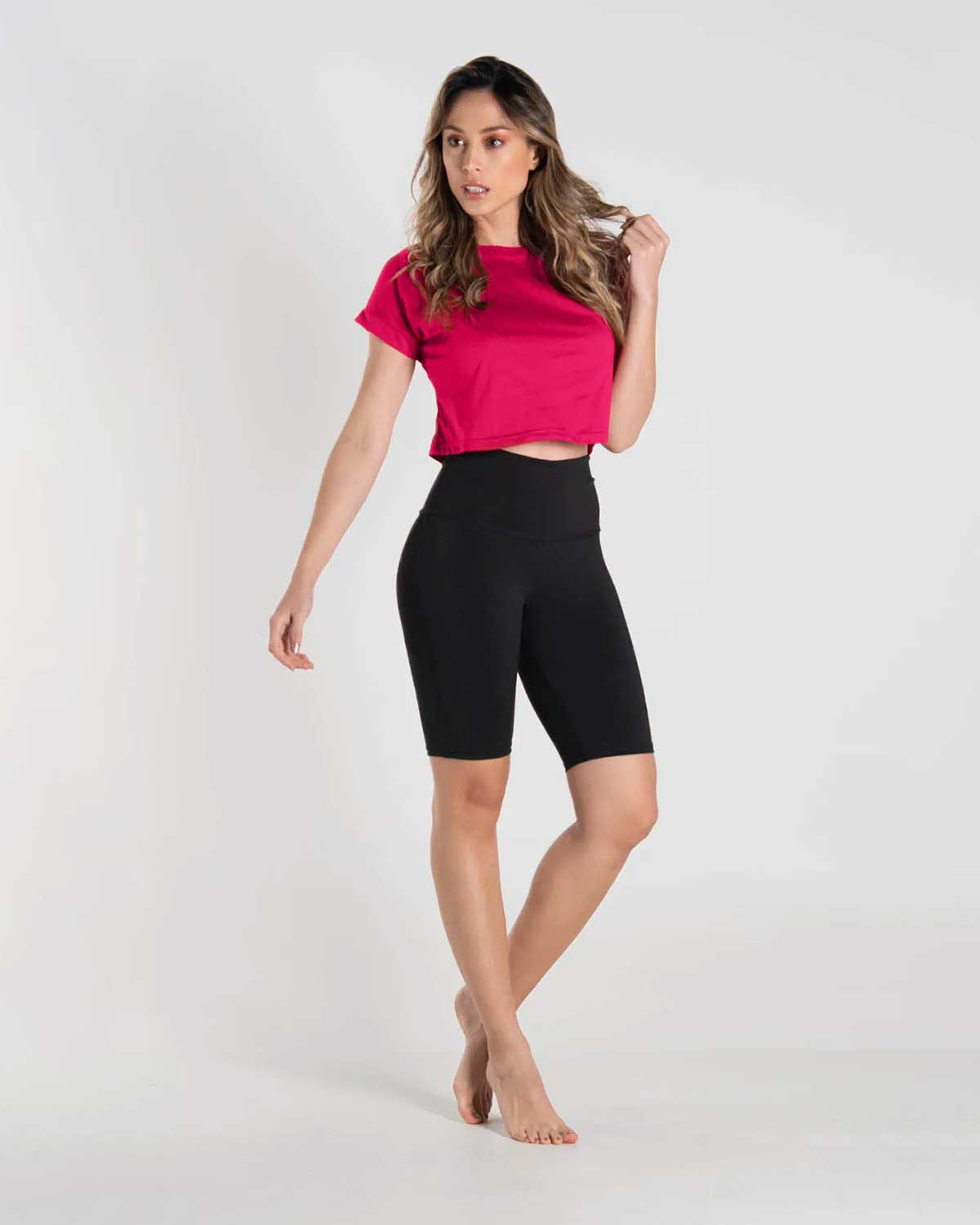 Mujer con set de camiseta fucsia y biker negro