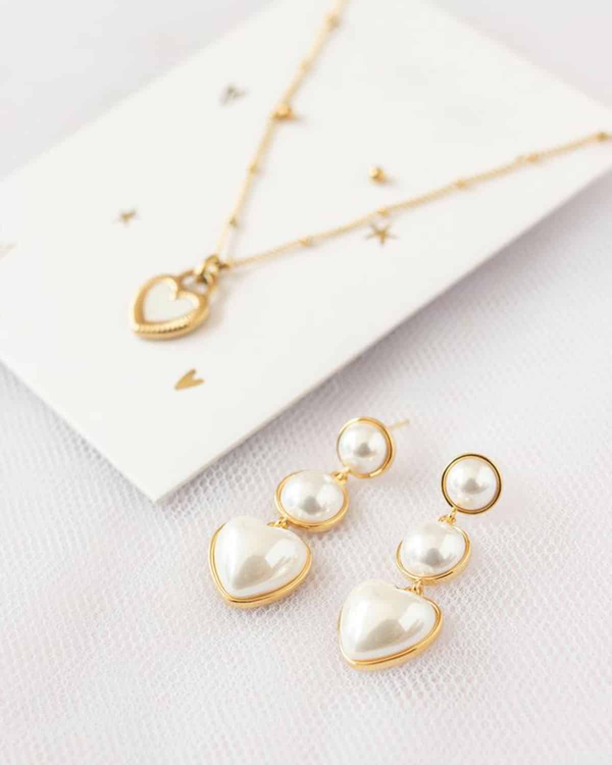 Aretes largos de perlas y acero con baño de oro.